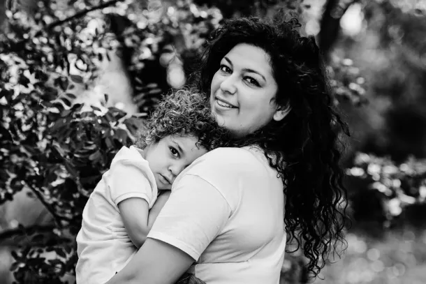 photo en noir et blanc d'un petit garçon qui fait un calin à sa maman