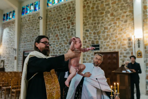 baptême orthodoxe avec le prêtre plonge le bébé dans l'eau et le ressort