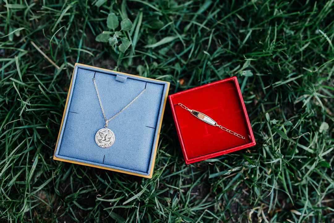 médaille et bracelet de baptême dans leurs boites posées dans l'herbe dans le val de marne