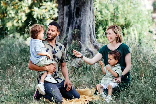 parents qui jouent avec leurs jumeaux sur un plaid dans un jardin dans le 94