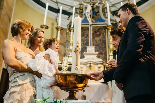 enfant qui rigole pendant son baptême