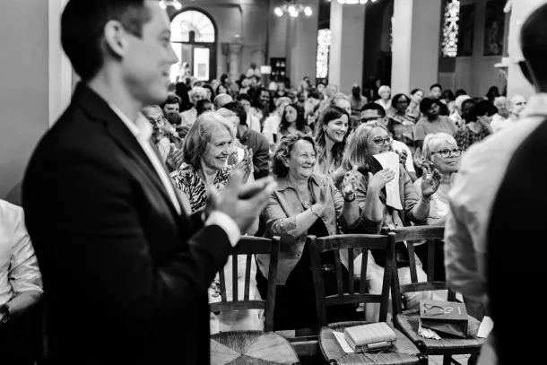 famille qui applaudit pendant un baptême à l'église dans le Val de Marne en noir et blanc