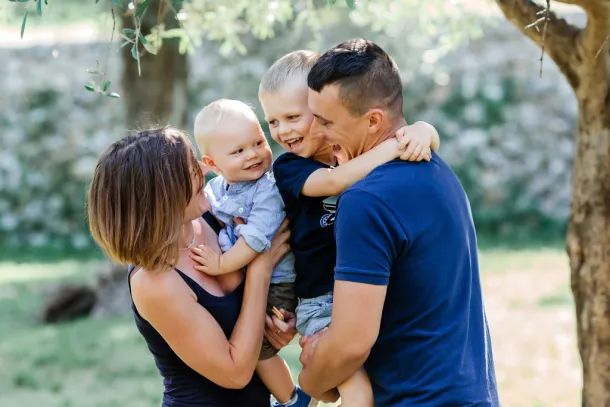 deux petits garçons dans les bras de leurs parents dans un parc à Nice
