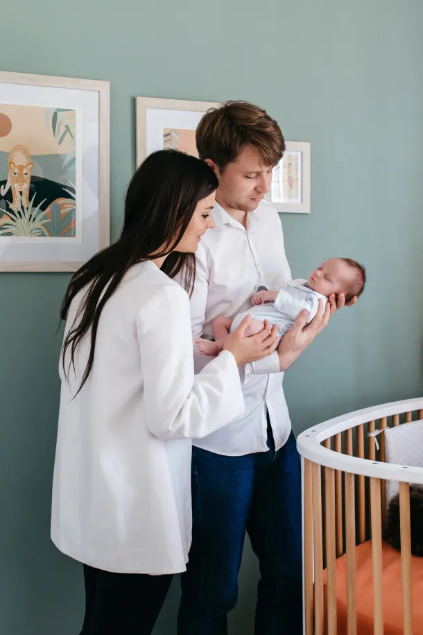 photos de naissance parents et bébé au dessus du berceau