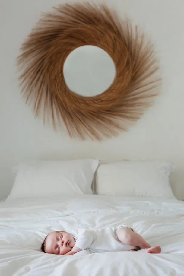 photo de bébé à domicile sur le lit de ses parents sur fond blanc